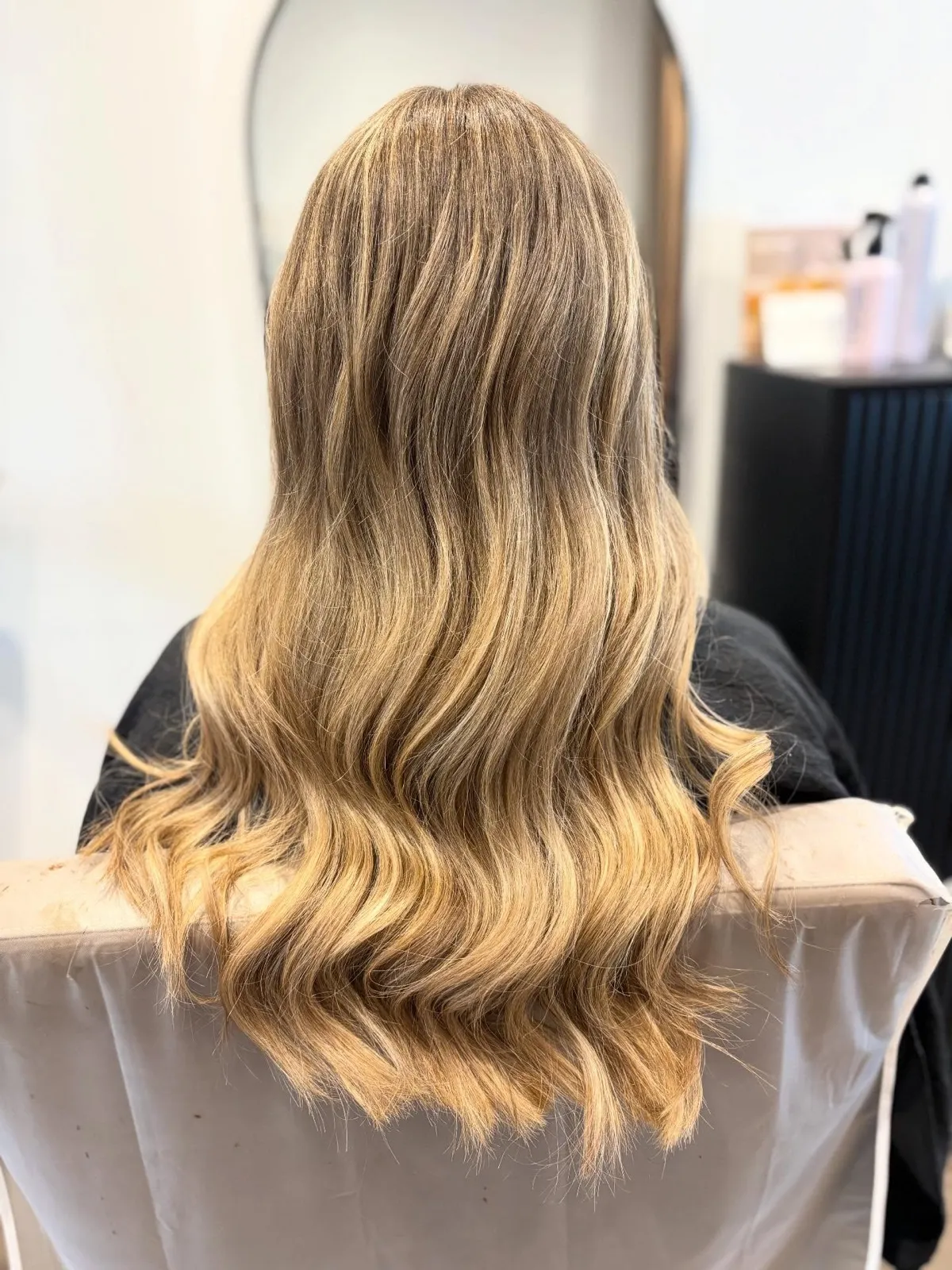 Rear view after: cooler dimensional blonde with a soft wave through the lengths.