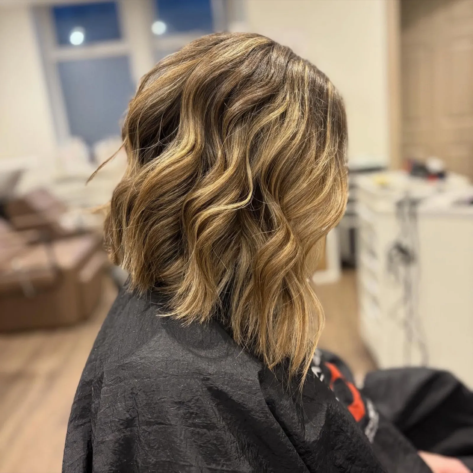 Side view after: a lived-in bronde bob with soft waves and lighter pieces around the face.