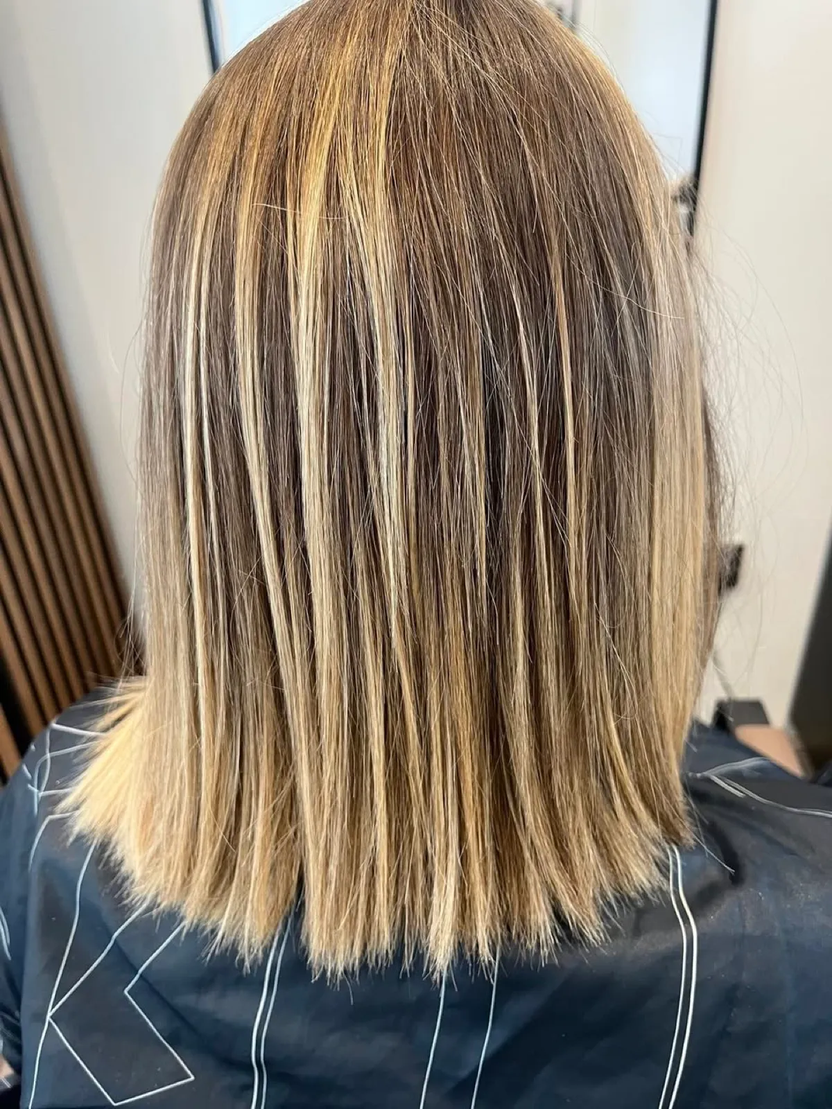 Rear view before: flat straight blonde with grown-out highlights and little depth.