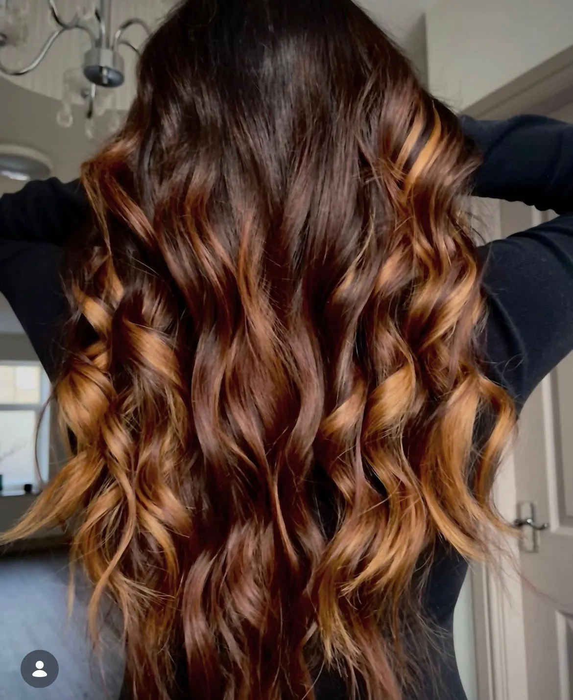 Long brunette hair with soft caramel waves through the lengths.
